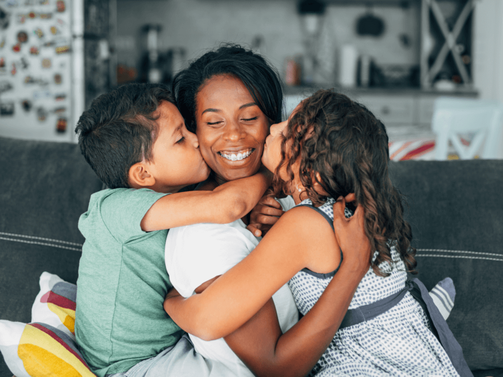 Mom receiving the rewards of parenting coaching with hugs from her kids
